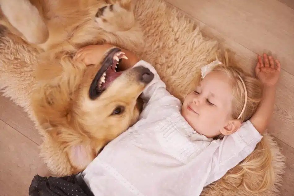 Un chien et une fillette blonde s'enlacent
