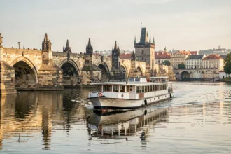 Bateau de croisière sur la Vltava passant sous le Pont Charles à Prague
