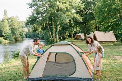 Famille heureuse installant une tente en Dordogne