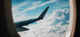 person taking picture of plane wings while flying during daytime