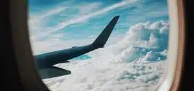 person taking picture of plane wings while flying during daytime